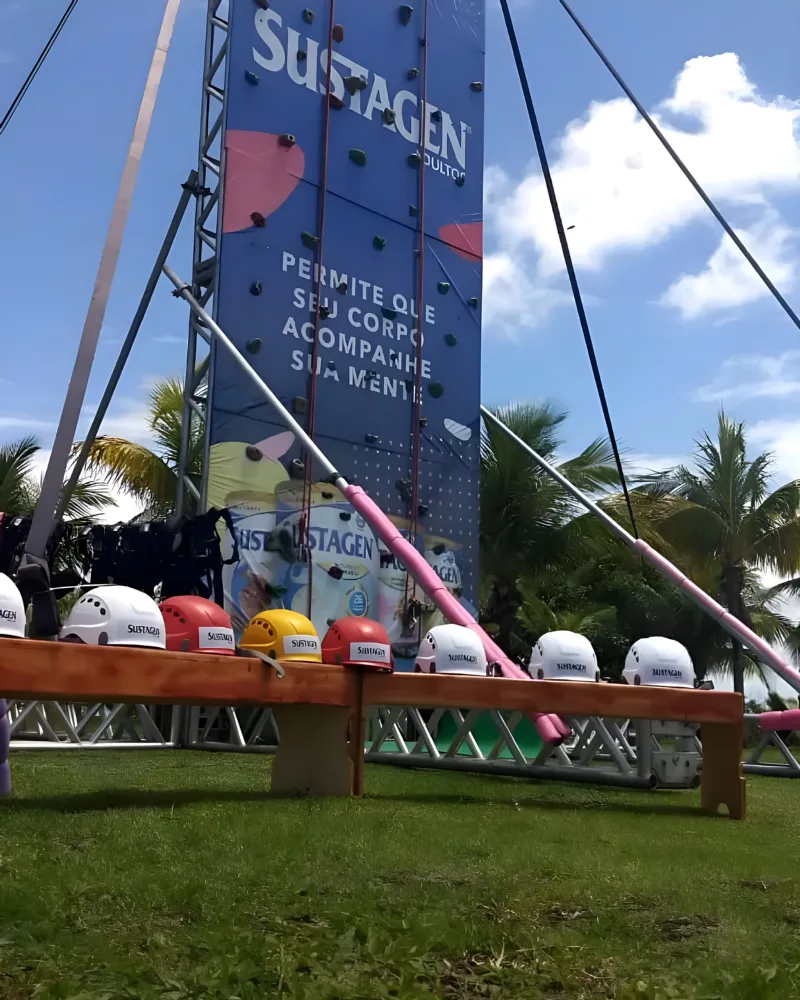 Torre de escalada com lona da marca e capacetes prontos para o público — Tribo da Trilha PE